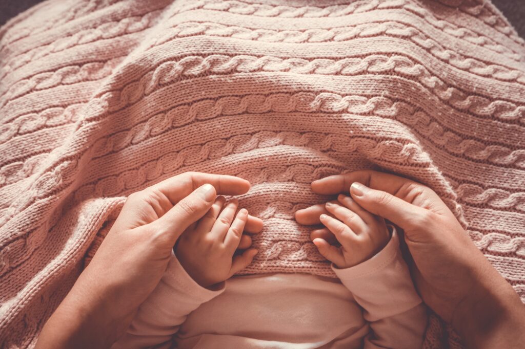 Mother holding her baby's hands